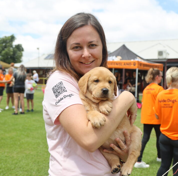 Woman holding a yellow labrador puppy